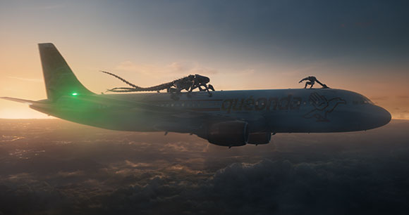 A dark, multi-limbed creature crawls along the top of a white airplane flying above a layer of clouds at sunset.