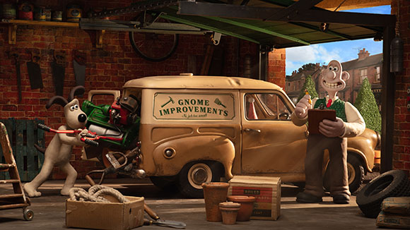 Claymation scene featuring a white dog loading a green machine into a tan van and a man holding a clipboard.