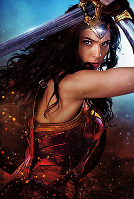 A woman with long dark hair in red and gold armor holds a large sword above her head.
