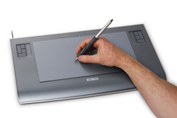 A person's hand holding a stylus and drawing on a grey digital graphics tablet.