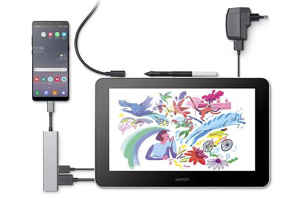 A smartphone connected to a Wacom drawing tablet via a hub, with a stylus and power adapter nearby.