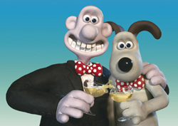 Claymation characters Wallace and Gromit in suits holding glasses of sparkling liquid.
