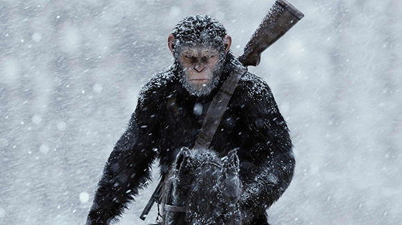 A chimpanzee wearing dark fur and a rifle slung over its shoulder walks through falling snow.