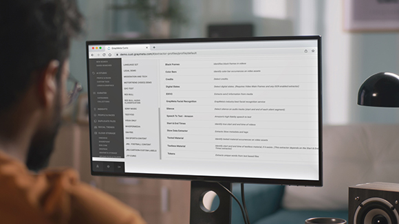 A person sits in front of a computer monitor displaying a list of video analysis features.