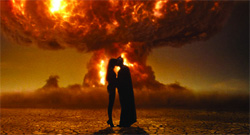 Silhouette of a couple kissing against a backdrop of a large, fiery explosion.