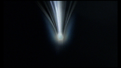 Bright white and blue light beams radiating upward from a central glowing point against a black background.