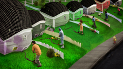 People use hoses to water large, rounded, colorful houses on a green lawn.