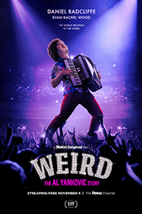 A man in a colorful shirt plays an accordion on a stage above a cheering crowd under purple lights.