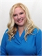 A smiling woman with long blonde hair wearing a bright blue v-neck shirt against a white background.