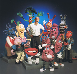 A man surrounded by a large group of diverse, colorful cartoon character figurines.