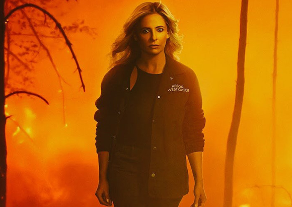 A woman wearing a jacket labeled 'Arson Investigator' stands before a bright orange, smoky background.