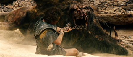 A man in ancient clothing pulls on a chain attached to a massive, snarling dark-furred monster.