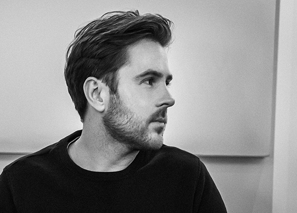 Black and white profile portrait of a man with short hair and a beard looking to the right.