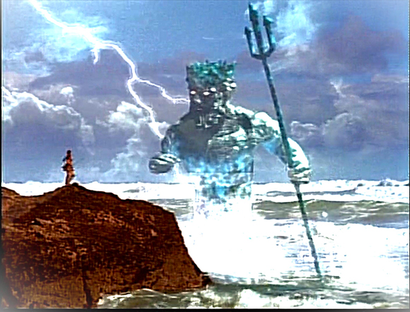 A colossal, glowing blue figure rises from the ocean waves holding a large trident near a rocky shore.