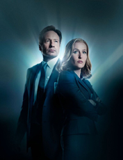 A man in a suit and a woman in a blazer stand back-to-back against a glowing blue light.
