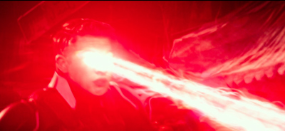 A person's face is struck by a bright, intense beam of red light.