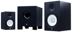 Three black studio monitor speakers of different sizes arranged from smallest to largest.