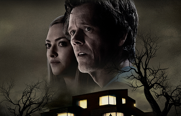 A man and woman with worried expressions look out over a dark building and silhouettes of bare trees.