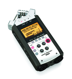 A black and silver handheld digital audio recorder with a glowing orange LCD screen and various control buttons.