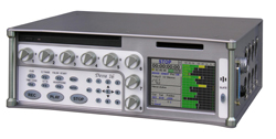 Silver electronic audio device with multiple control knobs, buttons, and a digital screen showing audio levels.
