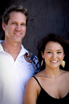 A smiling man in a white polo shirt and a woman in a black tank top standing side by side.