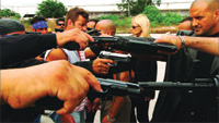 Multiple people aiming handguns and submachine guns toward the center of the frame.