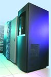 A row of tall, dark server racks illuminated by blue and teal lights in a data center.