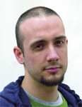 A man with short buzzed hair and a dark goatee looking toward the camera.