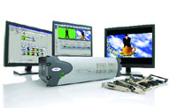 Three computer monitors displaying various digital interfaces and a cylindrical hardware device with a circuit board.