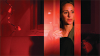 A woman looks thoughtfully into the distance under dim, red-toned lighting alongside a string of small lights.