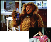 A person in a furry lion costume holding a blue water bottle in a kitchen setting.