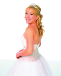 A smiling young woman with blonde hair wearing a white strapless gown and a small tiara.