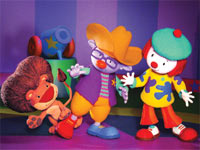 Three colorful puppets including a lion, a purple character in a yellow hat, and a clown in a green hat.