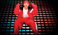 A man in a red tracksuit and red bandana poses with hands near his head against a grid of colored lights.