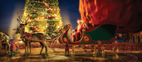 Santa Claus sits in a green and gold sleigh pulled by reindeer before a glowing Christmas tree at night.