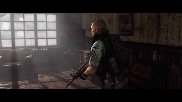 A soldier in tactical gear holds a rifle while looking toward a window in a dark, dusty room.
