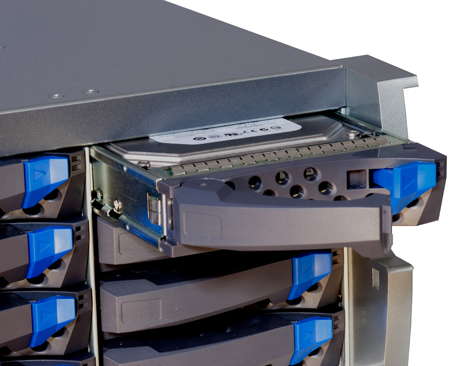 A hard drive being slid into a server rack bay with blue latches.