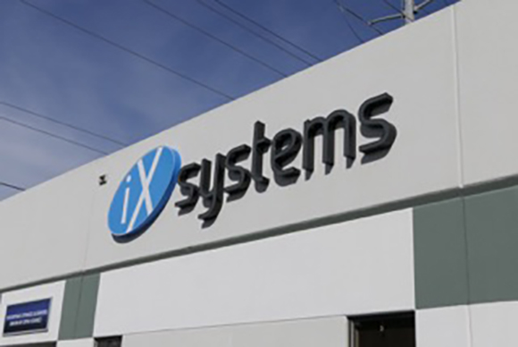 The iXsystems logo and name in black and blue lettering on a white building facade.