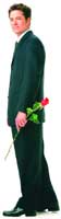 A man in a dark suit stands profile-view holding a single long-stemmed red rose.