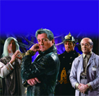 Four men in costume: a wizard, a man in black leather, a firefighter, and a scientist against a blue backdrop.