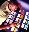 A person leans over a table, organizing several rows of small, colorful illustrated cards.