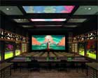 A dark news studio featuring a large central screen displaying a colorful landscape and multiple side monitors.