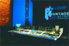 A professional audio mixing console with multiple screens and controls in a dark studio setting.