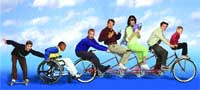 A diverse group of people posing with a wheelchair and a long tandem bicycle against a blue sky background.