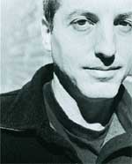 Black and white close-up portrait of a man looking toward the camera.