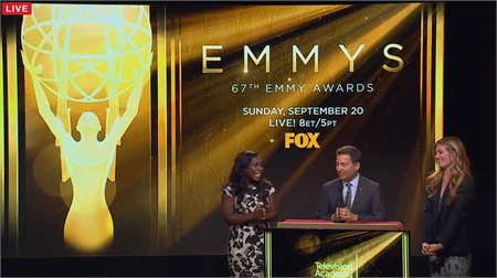 Three people stand before a gold screen promoting the 67th Emmy Awards on FOX.