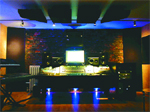 A music studio featuring a mixing console, monitors, and blue accent lighting.