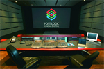 A dark color grading studio with a large screen displaying a logo and a control console with multiple monitors.