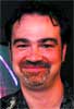 A smiling man with dark hair and a goatee looking toward the camera.