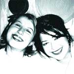 Black and white close-up of two smiling women looking toward the camera.
